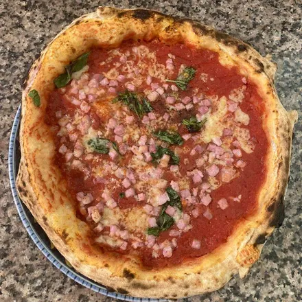 Pizza Carminuccio: pomodoro, pancetta a cubetti e foglie di basilico