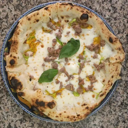 Pizza Ciurilli: base bianca con fiori di zucca, salsiccia sbriciolata e basilico