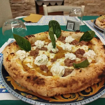 Pizza Sapori d'autunno: crema di zucca, salsiccia, ciuffi di ricotta e basilico